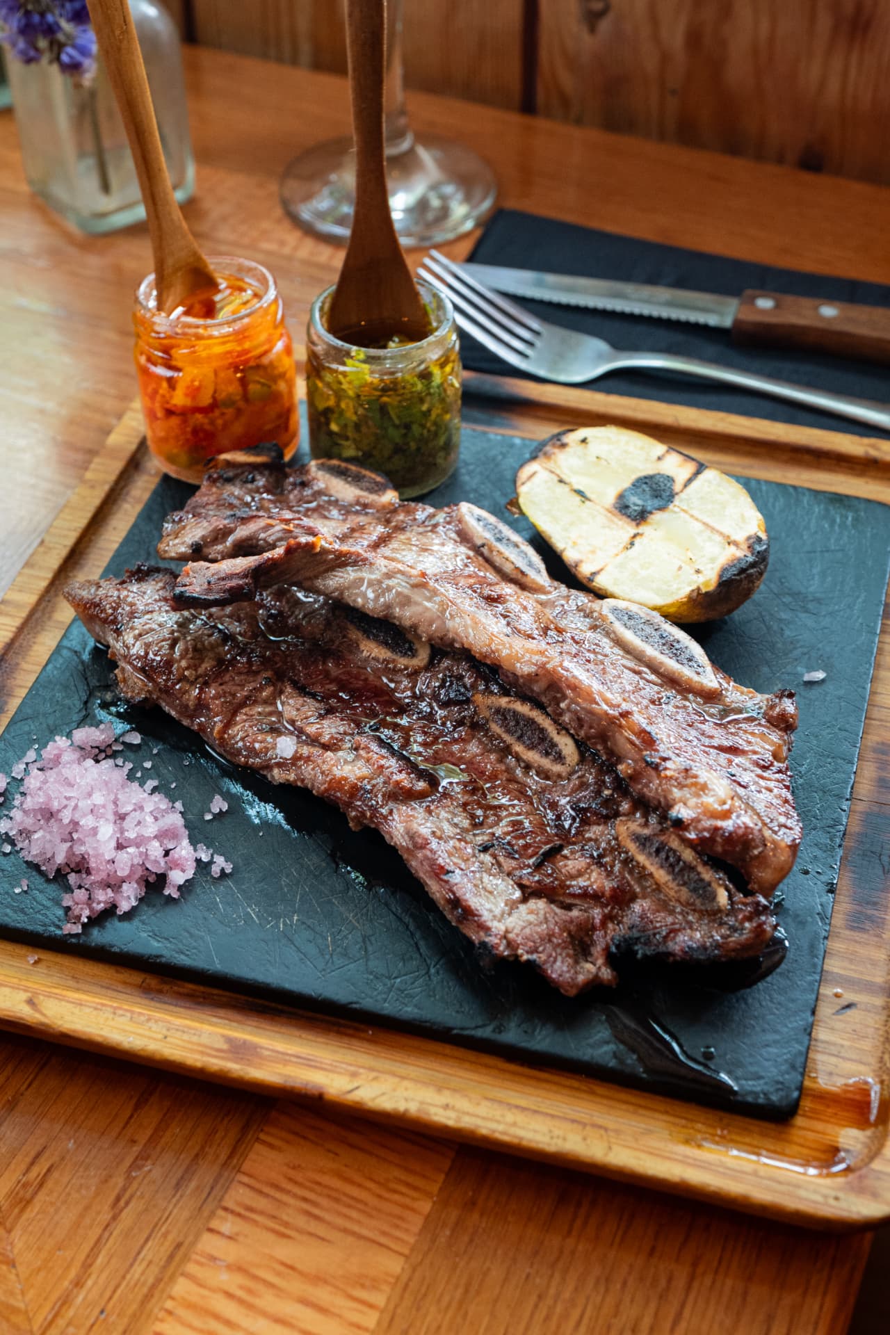 Grilled Argentine short ribs on slate with chimichurri and pink salt